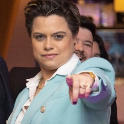 Beatrice Castro em evento, apontando para a câmera